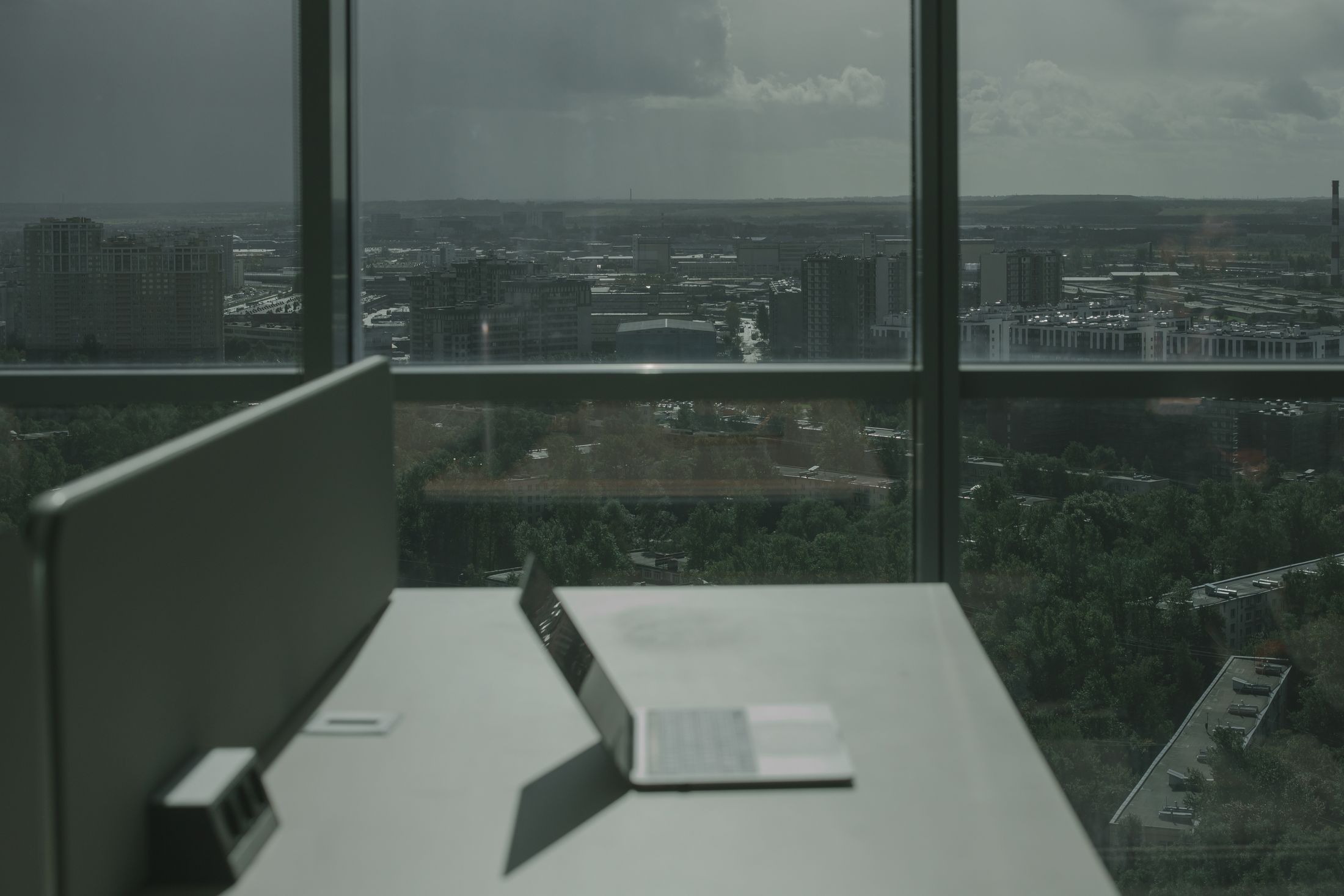 Laptop on an office desk overlooking a city skyline