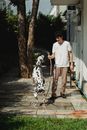 A Dalmatian Dog Enjoying the Water from the Hose