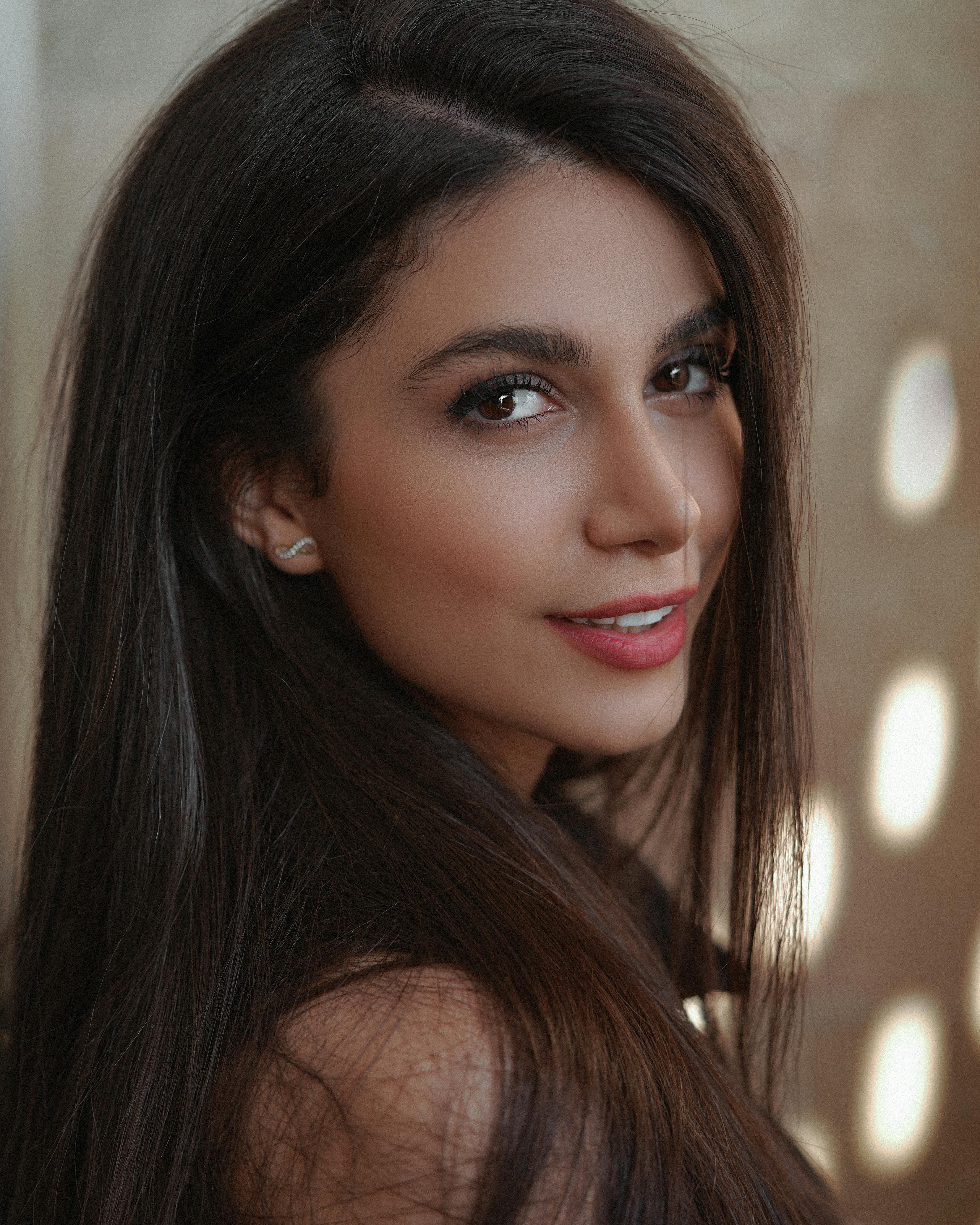 Beautiful portrait of a smiling woman with long brunette hair in soft natural light.