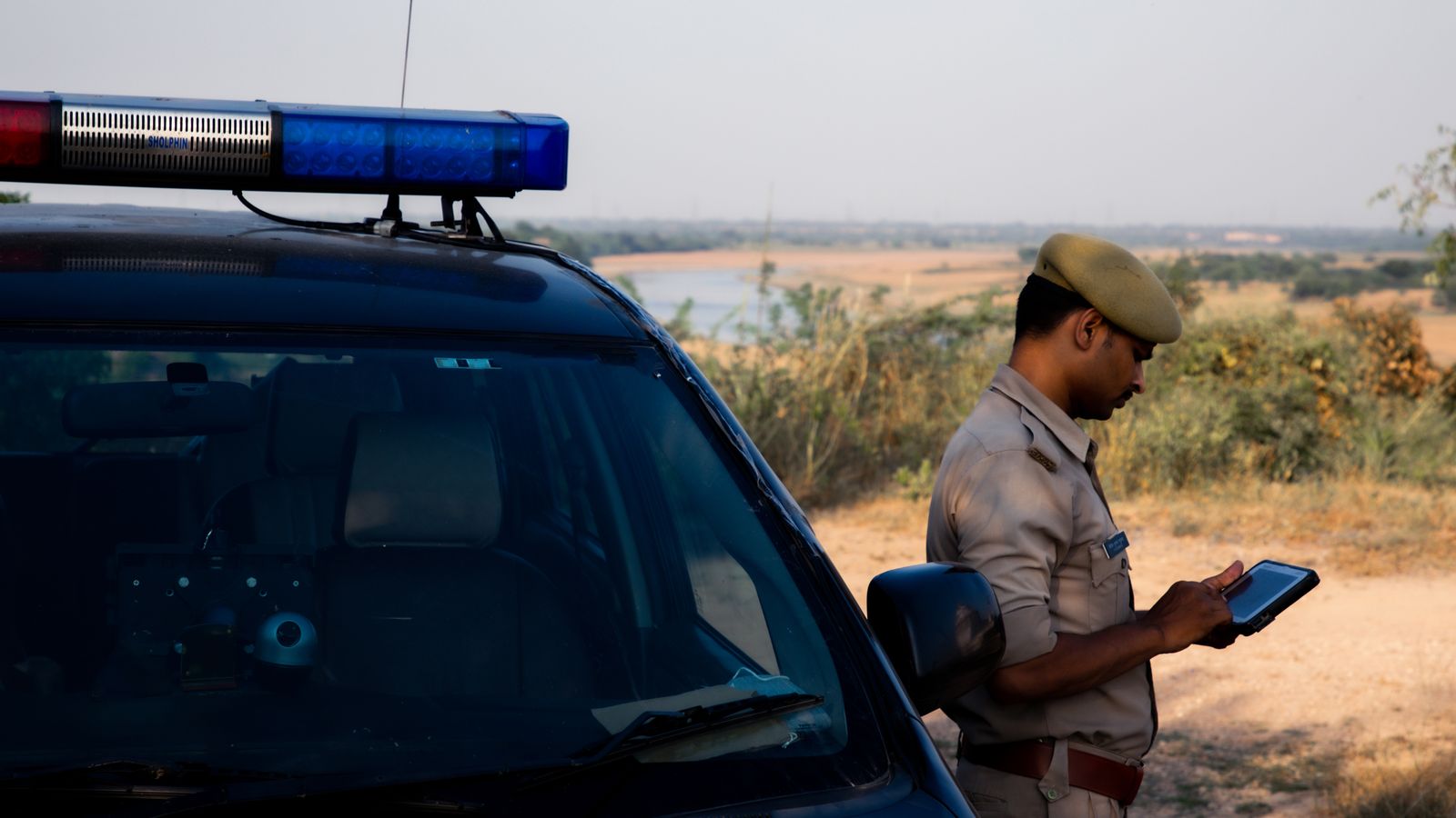Army officer standing by car in desert, Chad