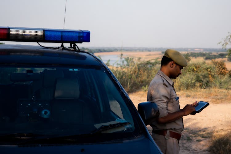 Army Officer Standing By Car In Desert