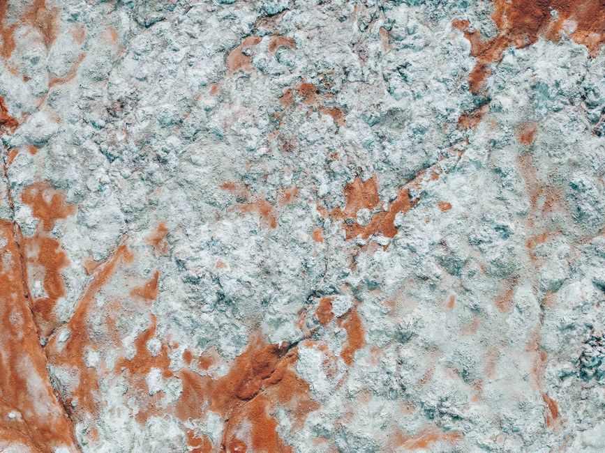 Aerial photograph showing a textured rock formation on a volcanic island with earthy tones.