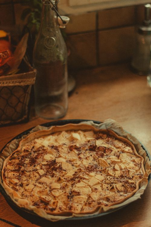 Free High angle of yummy apple pie with cinnamon placed on wooden kitchen table Stock Photo