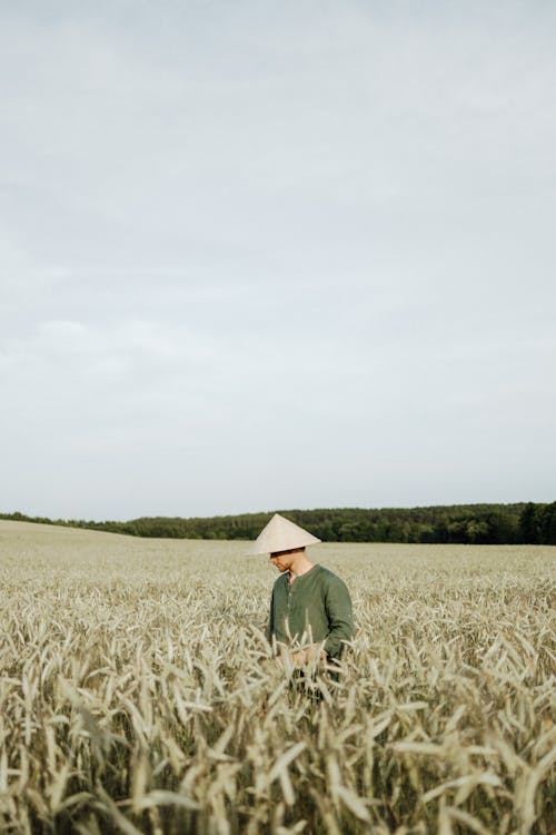 Man in Green Long Sleeve Shirt Standing on Green Grass Field