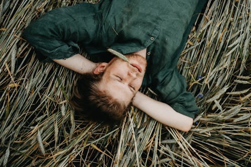Man in Dress Shirt Lying on Dried Grass