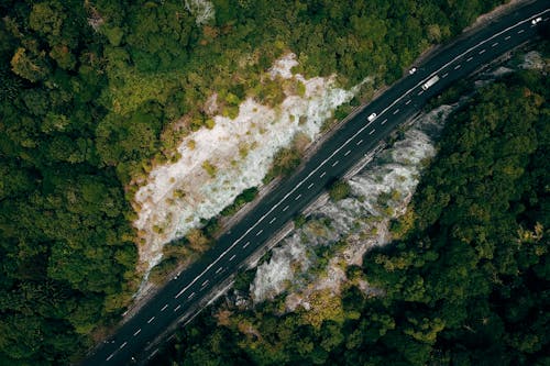 Asphalt road through green rocky valley