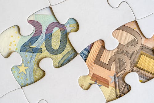 Free Money Bills Under a Jigsaw Puzzle Stock Photo