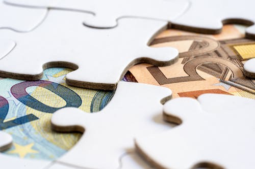 Free Banknotes Under a Jigsaw Puzzle Stock Photo