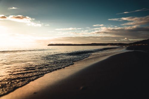 Free Beautiful sunset over a serene beach in Binz, Germany. Tranquil seascape with gentle waves and golden skies. Stock Photo