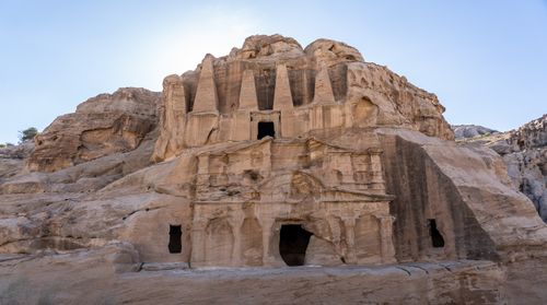 Free Explore this majestic ancient rock-cut temple nestled in a mountainous landscape, a marvel of historical architecture. Stock Photo