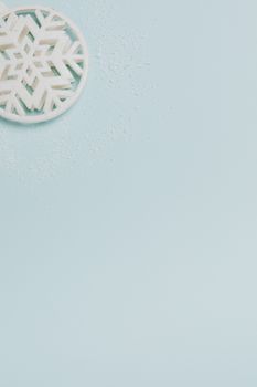 柔和的蓝色表面上装饰着白色雪花，周围环绕着细微的雪尘