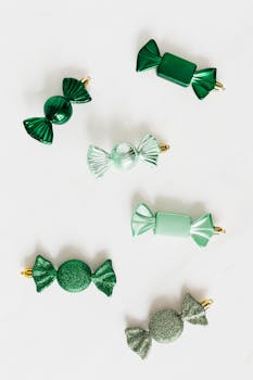 白色背景上排列着闪亮的绿色装饰糖果