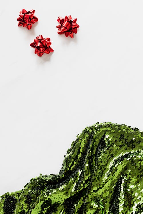 Red Ribbons and Green Sequin Cloth Free Stock Photo