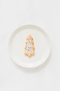 圣诞树糖饼干撒在极简主义白色盘子上