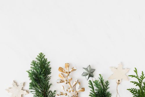 Free A flatlay of elegant Christmas decorations with greenery on a white background. Stock Photo