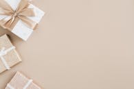 高角度视角下的丝带礼品盒，置于米色背景上，风格优雅简约