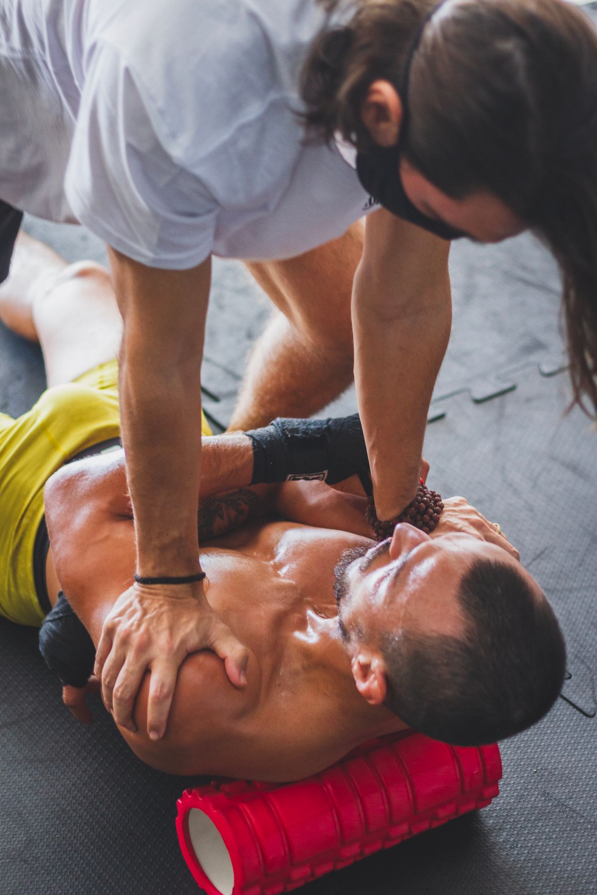 Man receiving recovery massage using a foam roller after training