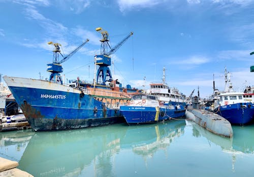 A Group of Blue and White Ships Docked Under Blue Skies