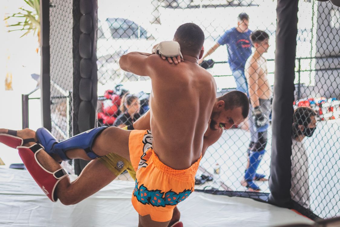 Muay Thai fight ringside with fighters exchanging strikes in Thailand arena
