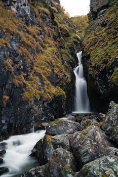 在挪威令人惊叹的风景中，宁静的瀑布从长满青苔的岩石上倾泻而下