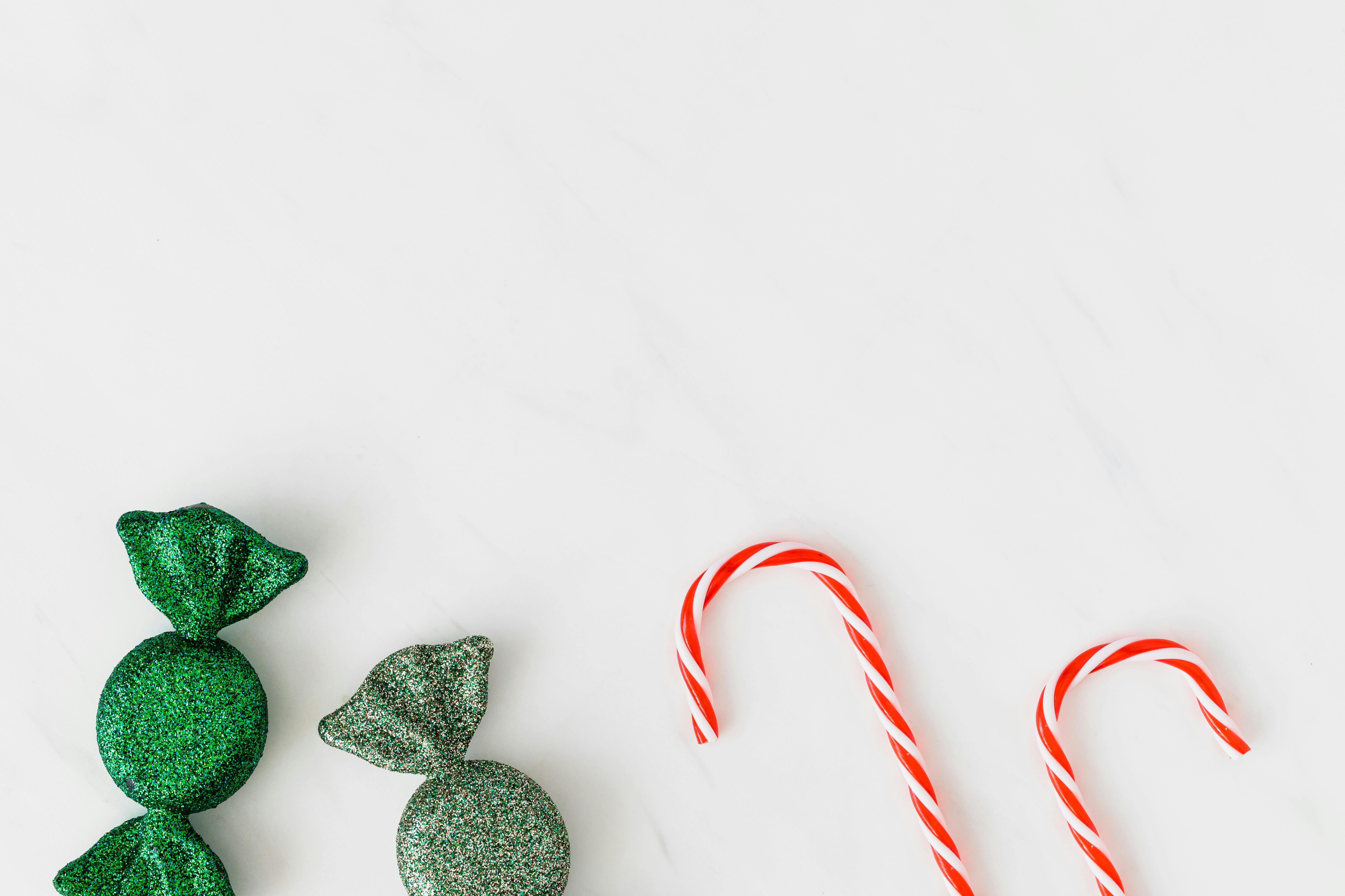 白色背景上，绿色糖果和红色糖果手杖明亮喜庆，非常适合节日庆祝