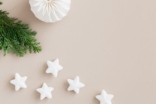 Free Elegant Christmas decoration featuring pine branches and star ornaments on a nude background. Stock Photo