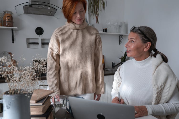 Women In A Kitchen Working On A Laptop 