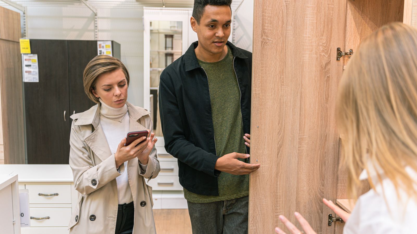 A man and woman shopping for wooden furniture in a modern retail store setting.