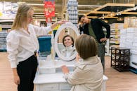 一群人在镜子反射和微笑中探索商店里的家具