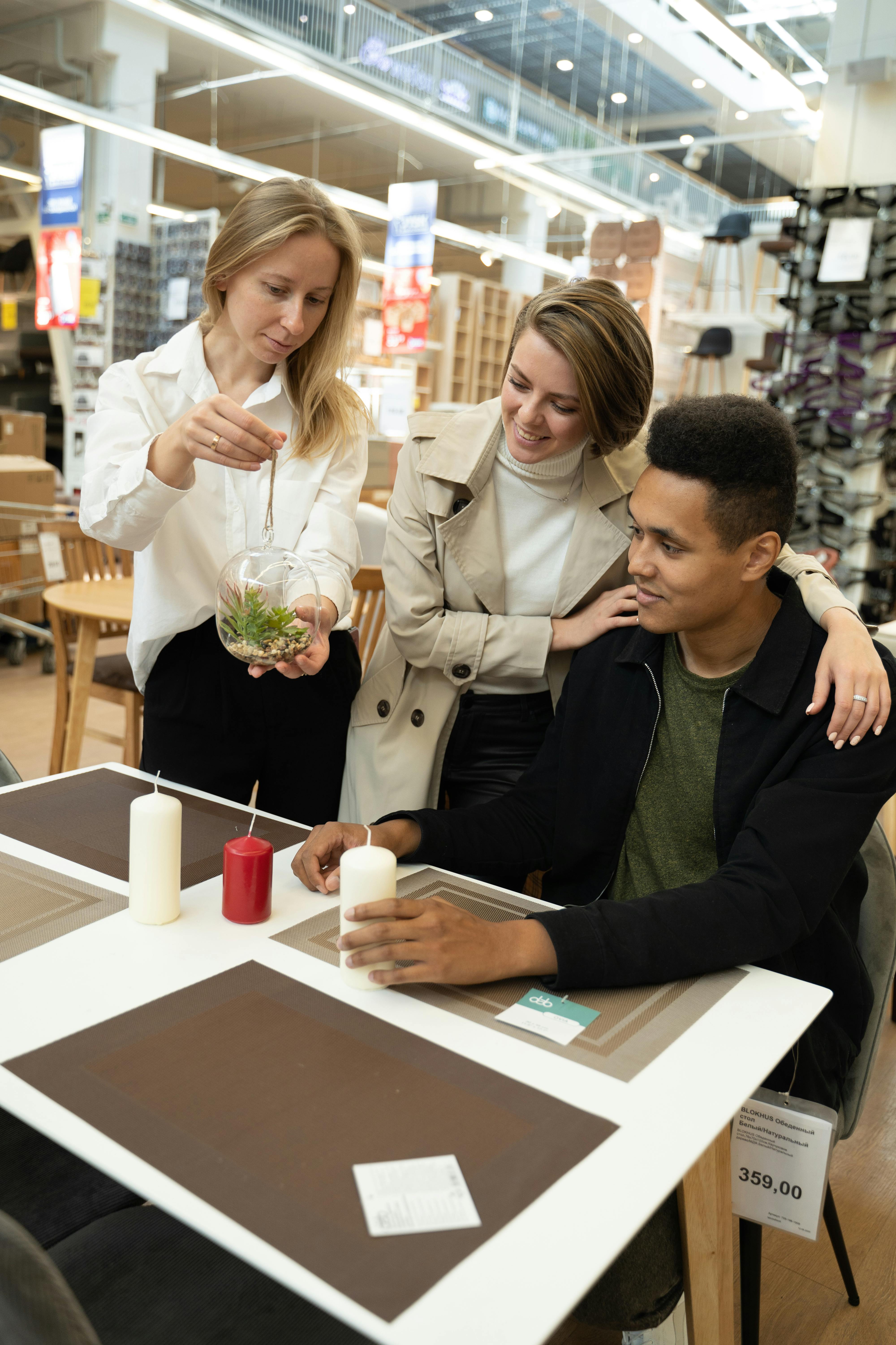 Three young adults exploring table settings and decor in a modern retail store.