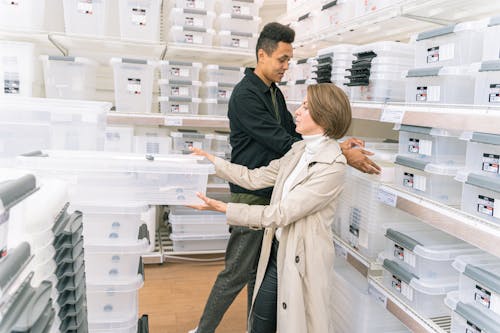 Free Man and Woman in Furniture Shop Choosing Storage Box Stock Photo