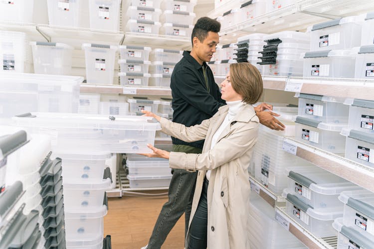 Man And Woman In Furniture Shop Choosing Storage Box