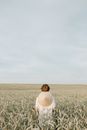 Back View of a Person Wearing Coolie Hat Standing Alone in the Middle of the Wheat Field