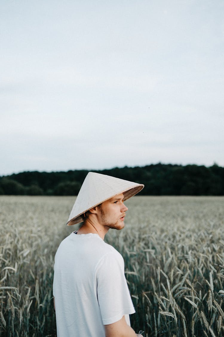 Man In White T-Shirt And Rice Hat Walking On Field