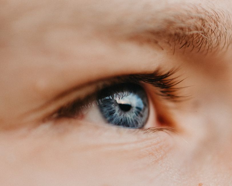 Macro shot of a blue eye showcasing detailed eyelashes and fine skin texture.