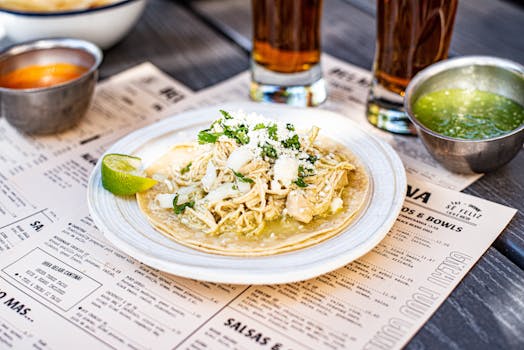 Savor a tasty chicken taco served with lime on a white ceramic plate, capturing authentic Mexican cuisine.