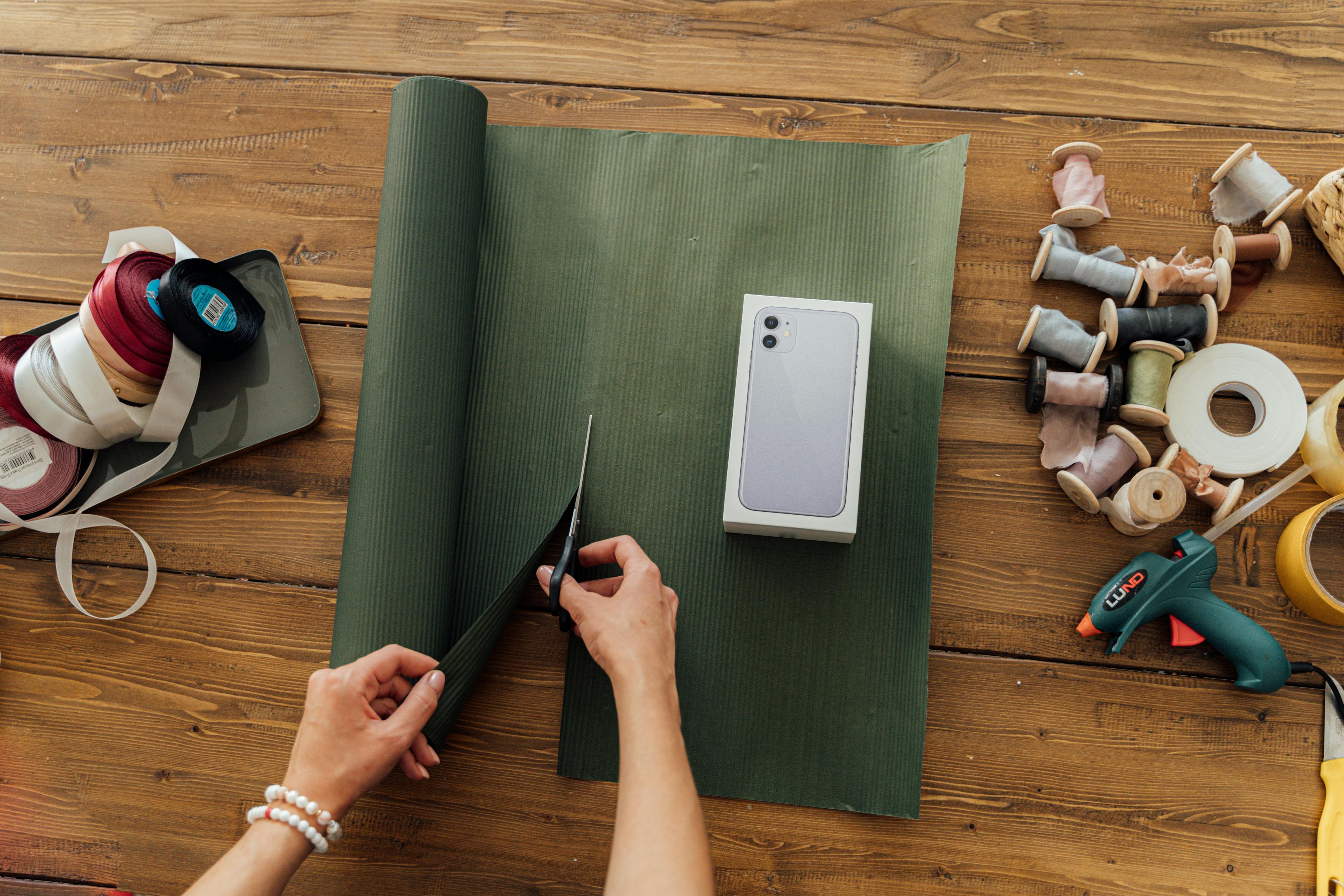 person packing iphone in wrapping paper