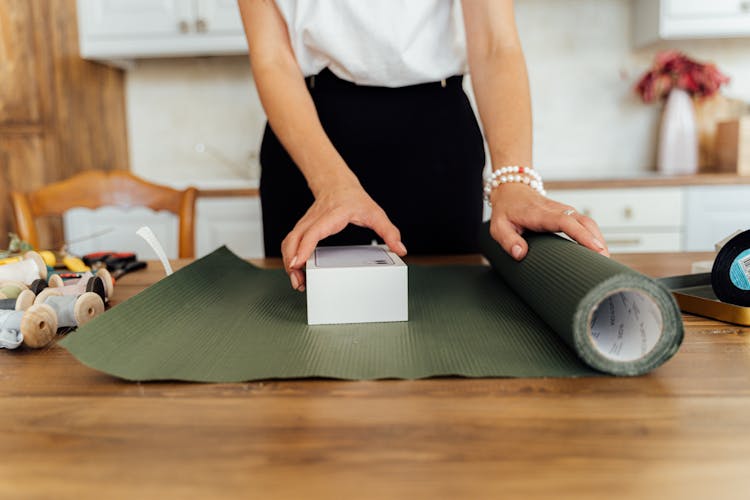 A Person Wrapping A Gift