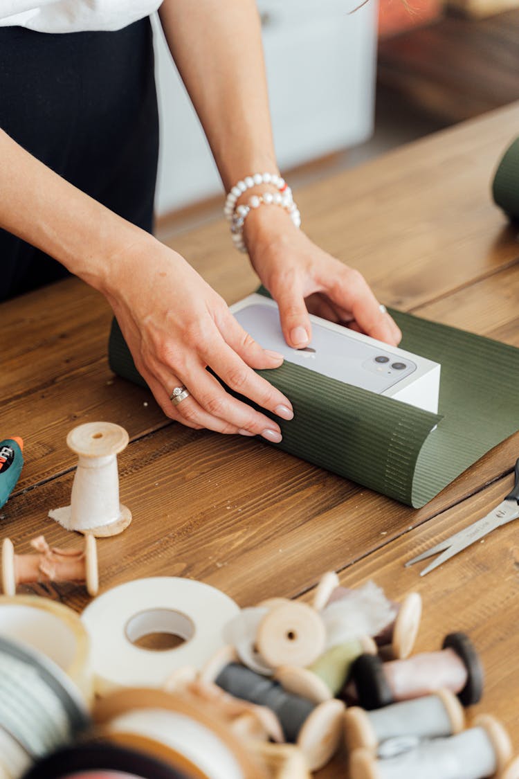 A Person Wrapping A Gift