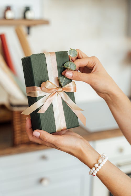 Free Person Holding a Gift with Ribbon Stock Photo