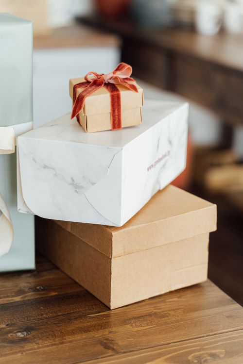 Free Stacked gift boxes with bows on a wooden table, perfect for celebrations. Stock Photo