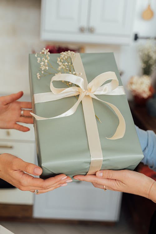 Free Person Holding Green and White Floral Gift Box Stock Photo