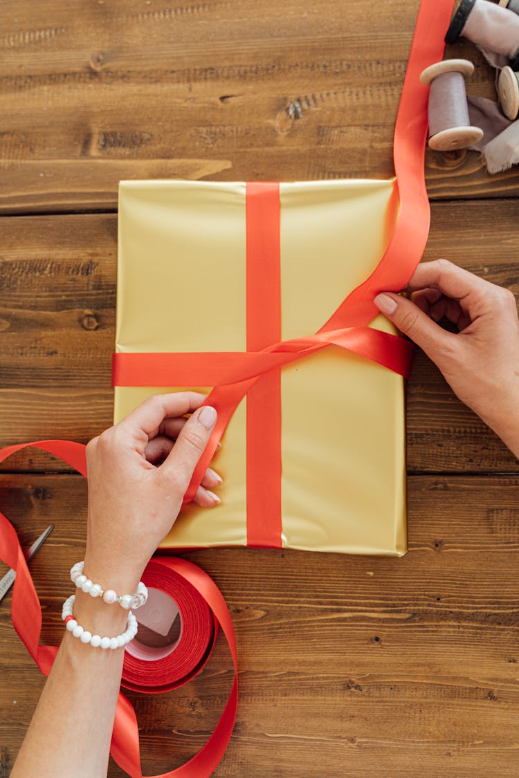 A Person Wrapping A Gift