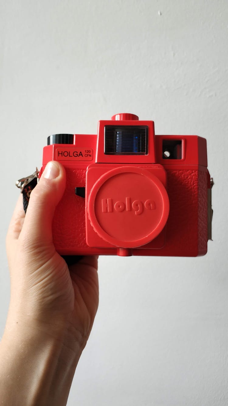 A Person Holding A Red Polaroid Camera