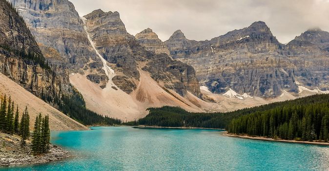 Breathtaking view of a mountain range with a turquoise lake, perfect for nature lovers and travelers.