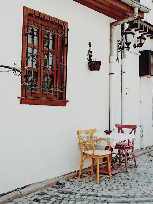 Free Colorful chairs and table outside a quaint building in Altındağ, Ankara enhance a charming street scene. Stock Photo