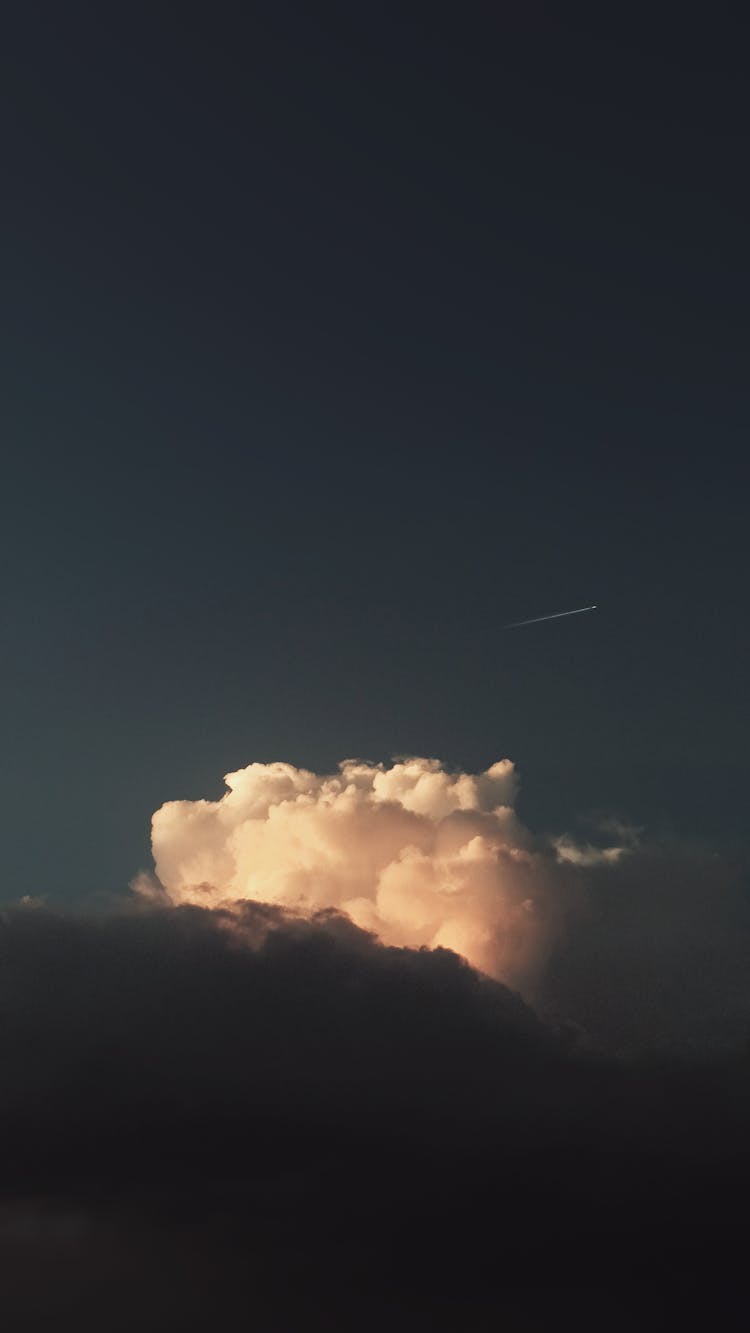 Vapour Trail Above Cumulus Clouds