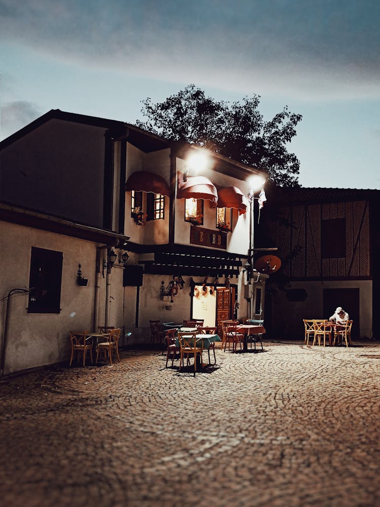 Tables In Empty House Yard At Night