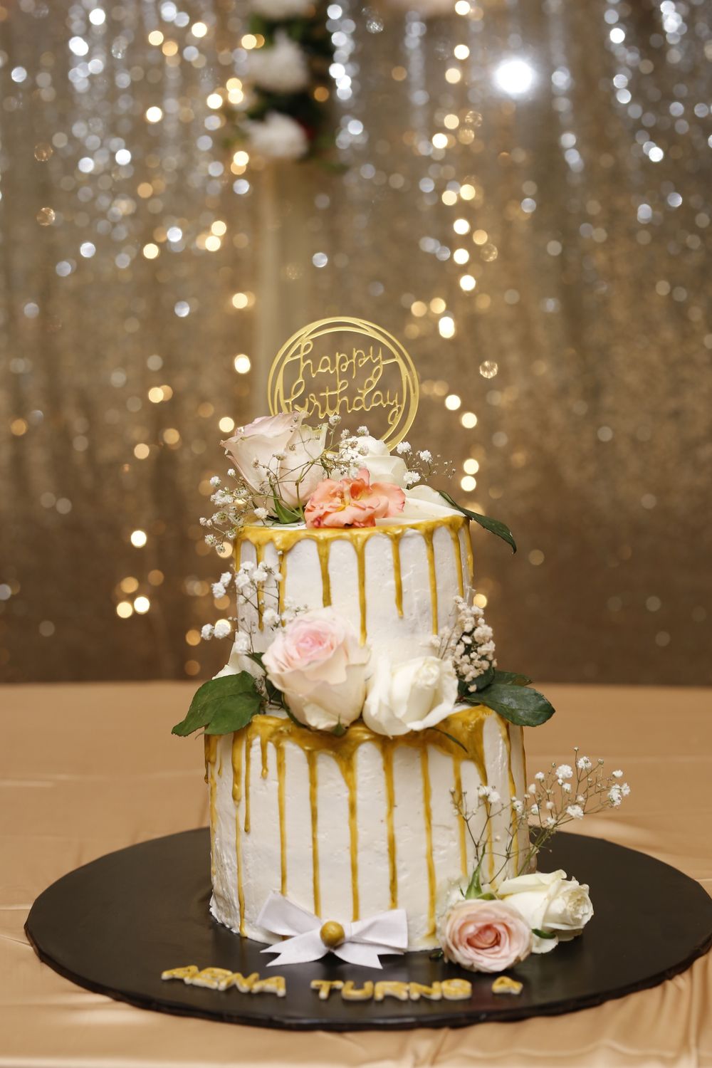 Hoorain Atelier two-tier floral celebration cake with gold accents
