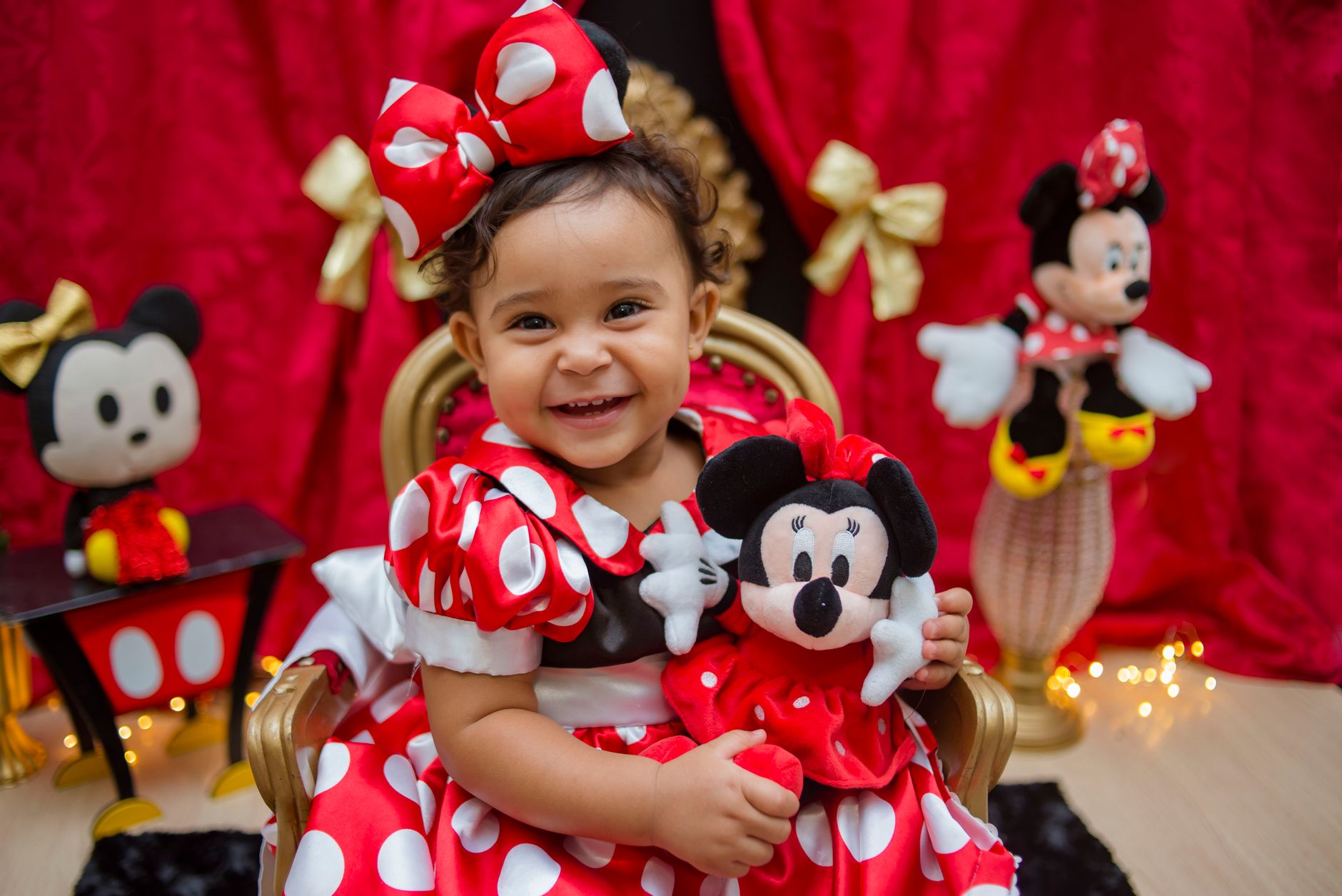 VIP mascots and entertainers Egypt — Charming toddler in a Minnie Mouse costume holding a plush toy and smiling brightly.